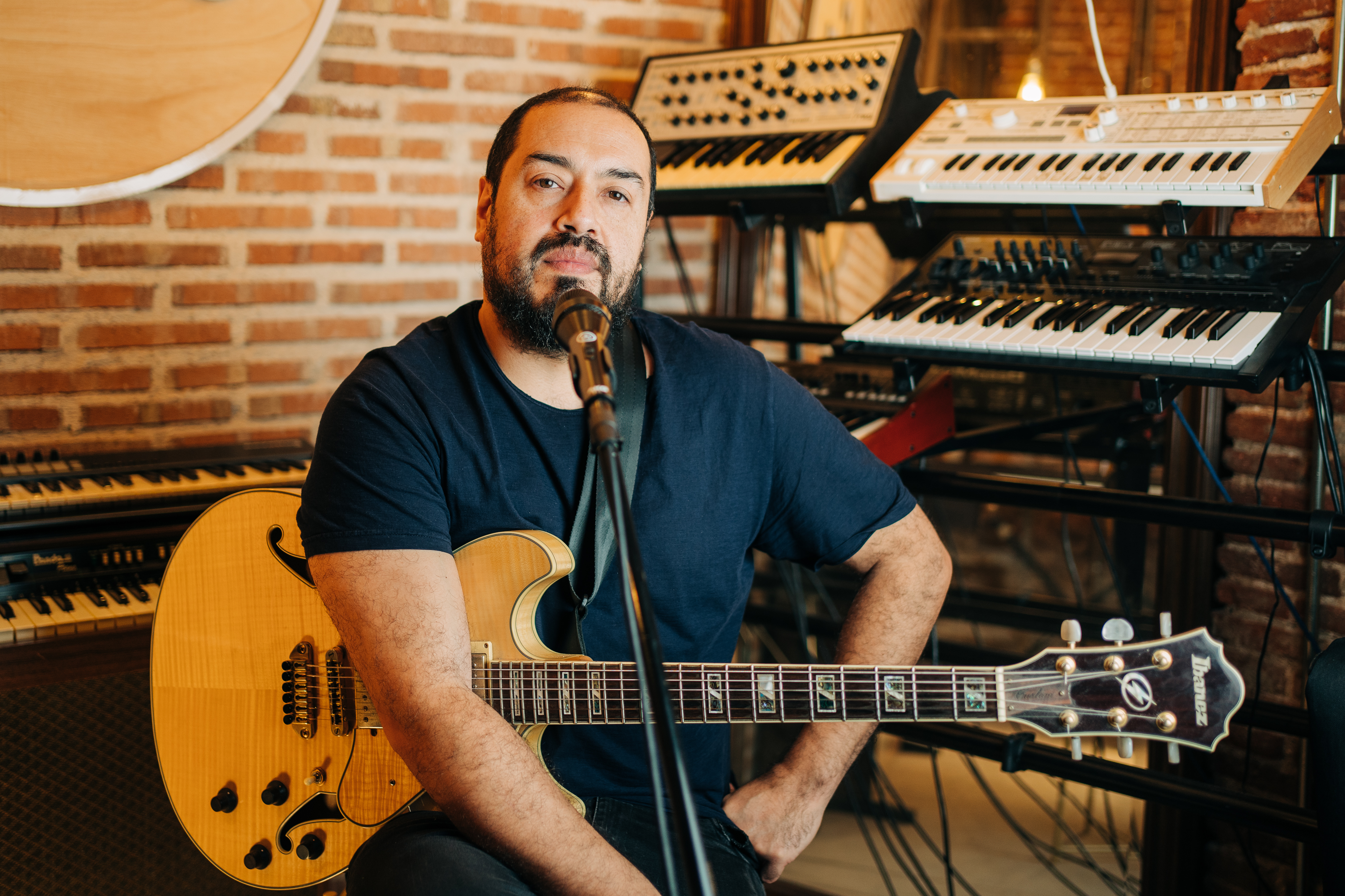 Daniel Román seated with an electric guitar in a recording studio